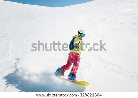 Woman snowboarding on a sunny day in the ski resort of Livigno - Italy