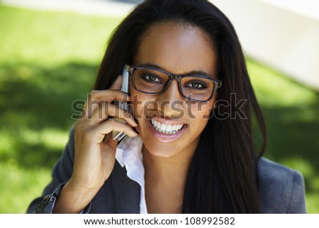 Portrait of a happy Phone african businesswoman - outdoors