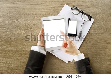 Young businesswoman working with graphics on digital tablet computer and smart phone. hands touching on tablet in a office