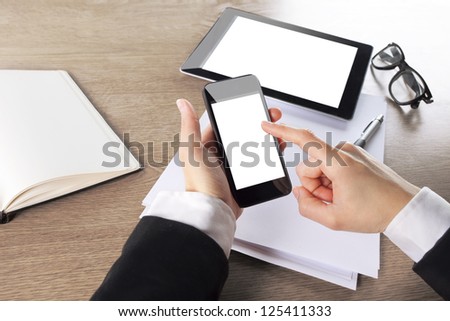 Young businesswoman working with digital tablet computer and smart phone. hands touching on digital mobile phone in a office