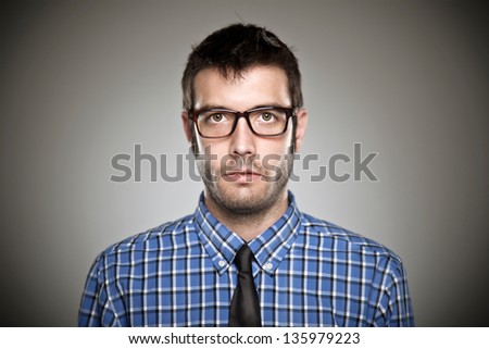 Portrait of a normal boy with glasses over grey background. / Young man face, high detailed portrait.