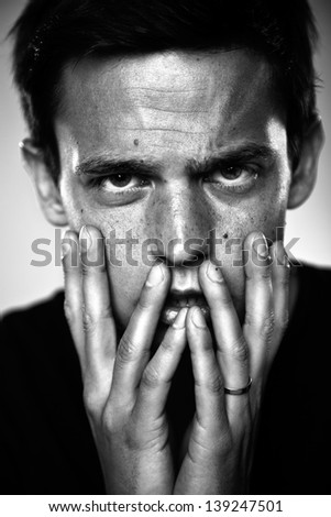 Attractive young man in studio looking at camera/ Young man portrait close up. Black and white