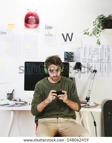 Young creative designer man at phone working at office  / Creative man.