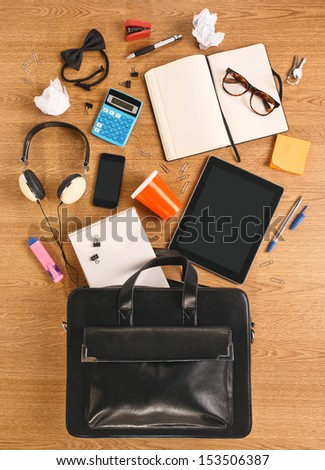 The Contents Of A Business Briefcase On A Wooden Desk. Different Business Objects.