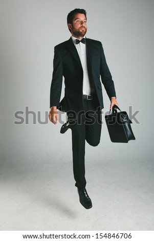 Young businessman in studio. / Stylish young man with black suit and briefcase.