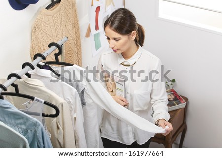 Fashion woman with magazine working in her office./ Fashion woman choosing a piece for the new collection.