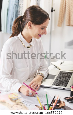 Young woman doing fashion sketches./ Fashion woman blogger working in a creative workspace.