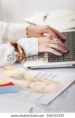Young creative woman typing on a laptop in her office./ Close up o fa fashion hand\'s woman blogger working in a creative space.