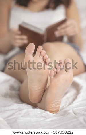 Portrait of woman reading a old book in a bed.
