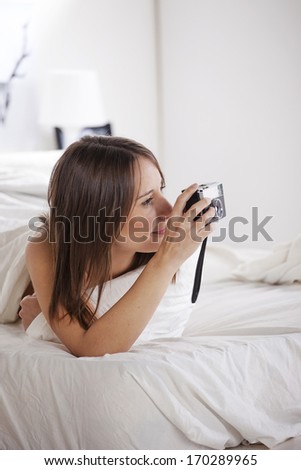 The white bedroom./Young woman taking a photo with old camera.