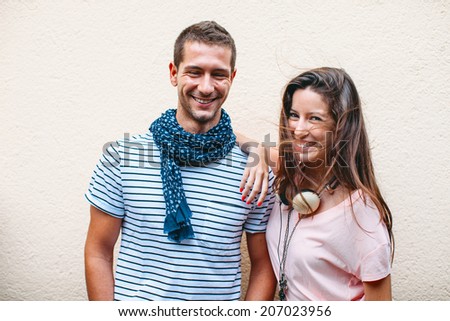 Smiling couple isolated on wall./ Portrait of a beautiful young couple.