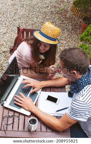 Beautiful couple smiling in your home garden./ Young couple working with laptop in outdoors.