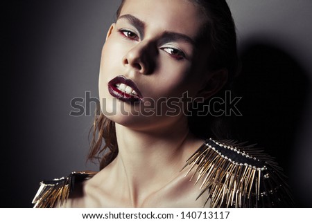 Sexy strict woman with red lips and epaulettes over dark background