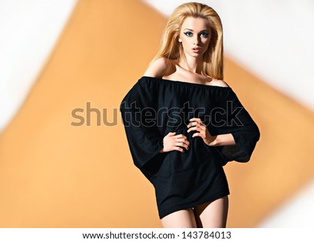 Fashion portrait of beautyful woman in tunic with orange rhomb on background