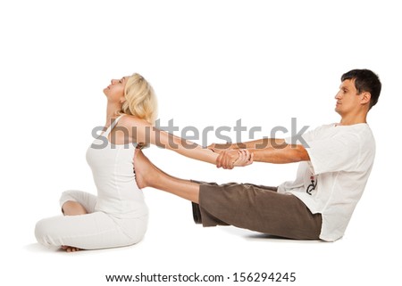 Young female sitting and receiving traditional thai arm stretching massage by therapist, isolated on white