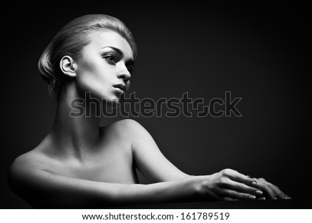 Beautiful high fashion female model with abstract hair style behind the table
