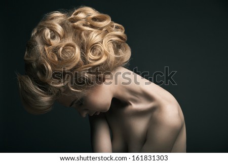 Beautiful High Fashion Female Model With Abstract Hair Style Behind The Table