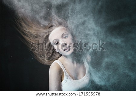 Emotional sexy Wild Woman with Flying hair and ashes over dark background