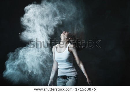 Emotional sexy Wild Woman with Flying hair and ashes in jeans over dark background