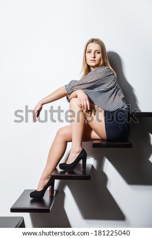 sexy woman lying on stairs over grey bakground