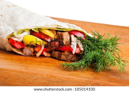 beef burrito with yellow and red peppers, onion and tomato on plate