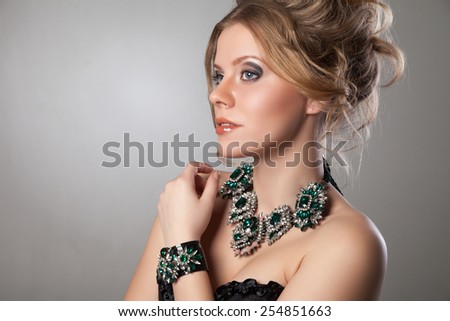 Portrait of beautiful woman with evening make-up and big necklace and bracelet. Jewelry and Beauty. Fashion photo