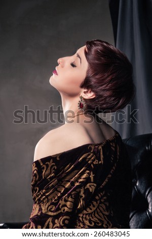 Portrait of  attractive young woman with short dark hair and beautiful hairstyle, head back. Rear view.