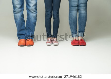 barefoot  legs of mother, father and little child wearing  jeans isolated on white background