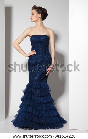 young beautiful brunette in dark blue dress on white