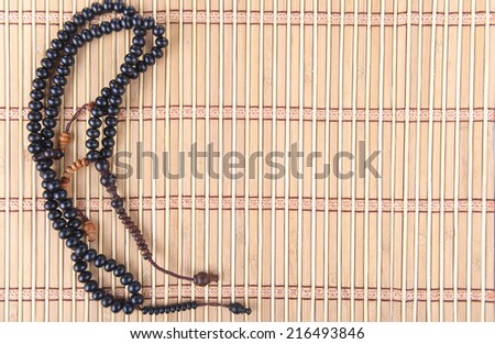 Tasbih on bamboo mat. Wooden rosary