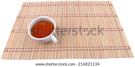 Close up view of a cup of tea on bamboo mat