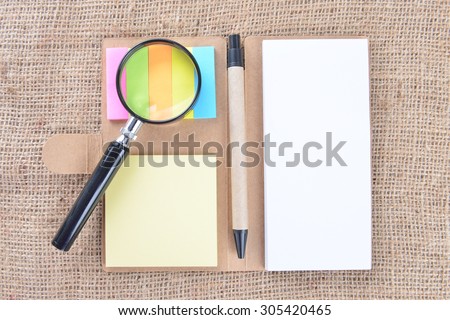 note book, magnifying glass on gunny. Education Concept