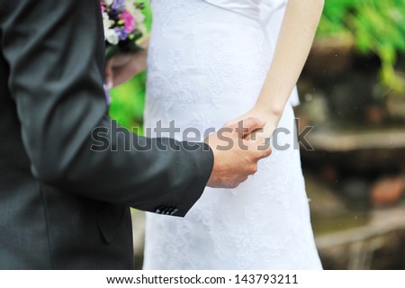 Bride and groom holding each other by the hand