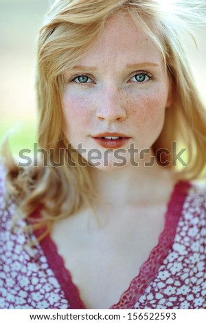 Face of a beautiful girl with freckles closeup