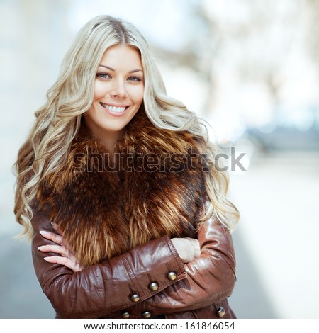 Beautiful smiling blonde woman with arms folded