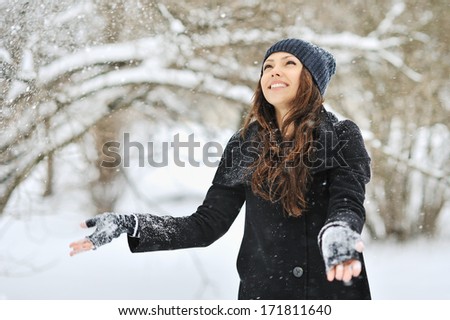 Beautiful woman throws snow in park