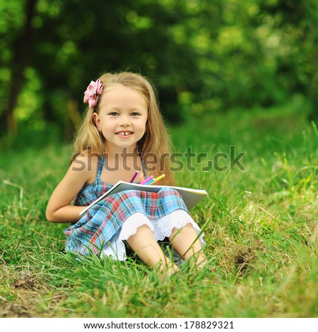 Cute little girl with pencils and note in a park
