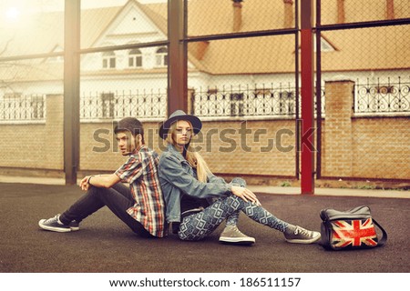Young couple in love outdoor. Sitting back to back together