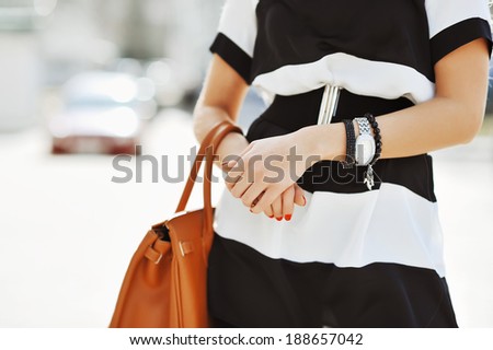 Fashionable woman with handbag in hands - close up