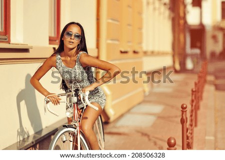 Sexy woman with vintage bike in a old town