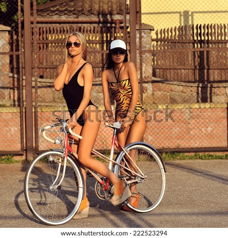 Two sexy women with vintage bike. Outdoor fashion portrait