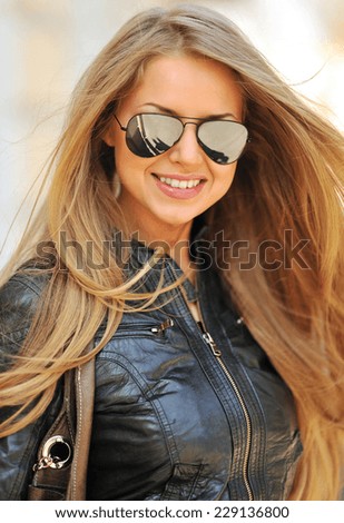 Fashion portrait of beautiful smiling woman wearing sunglasses - close up