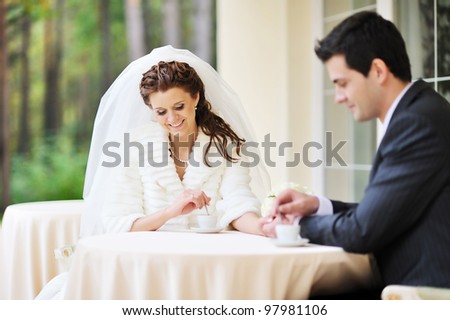 Bride and Groom drink coffee at an outdoor cafe