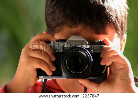 image of a boy taking picture with an SLR camera