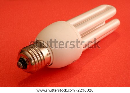 image of a power saving light bulb on red surface