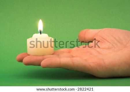 hand holding a candle (green background)
