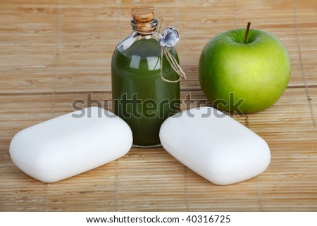 soap bars and liquid soap and apple on straw matt