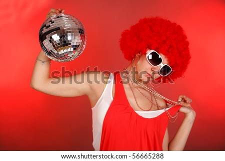 young woman  in fancy dress and red wig holding a mirror ball red gel used for the background