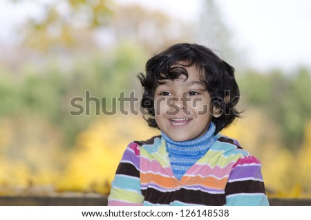 Cute Girl Playing In a Park with Background Fall Color Leaves
