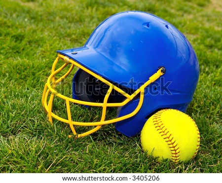 Softball batter's helmet and softball on grass